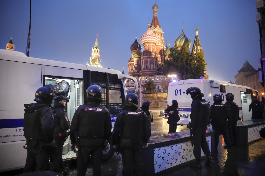 Police officers stand near police buses with detained demonstrators during a protest against a partial mobilisation near Red Square with the Spasskaya Tower and St Basil’s Cathedral in the background in Moscow, Russia on Saturday. Photo: AP