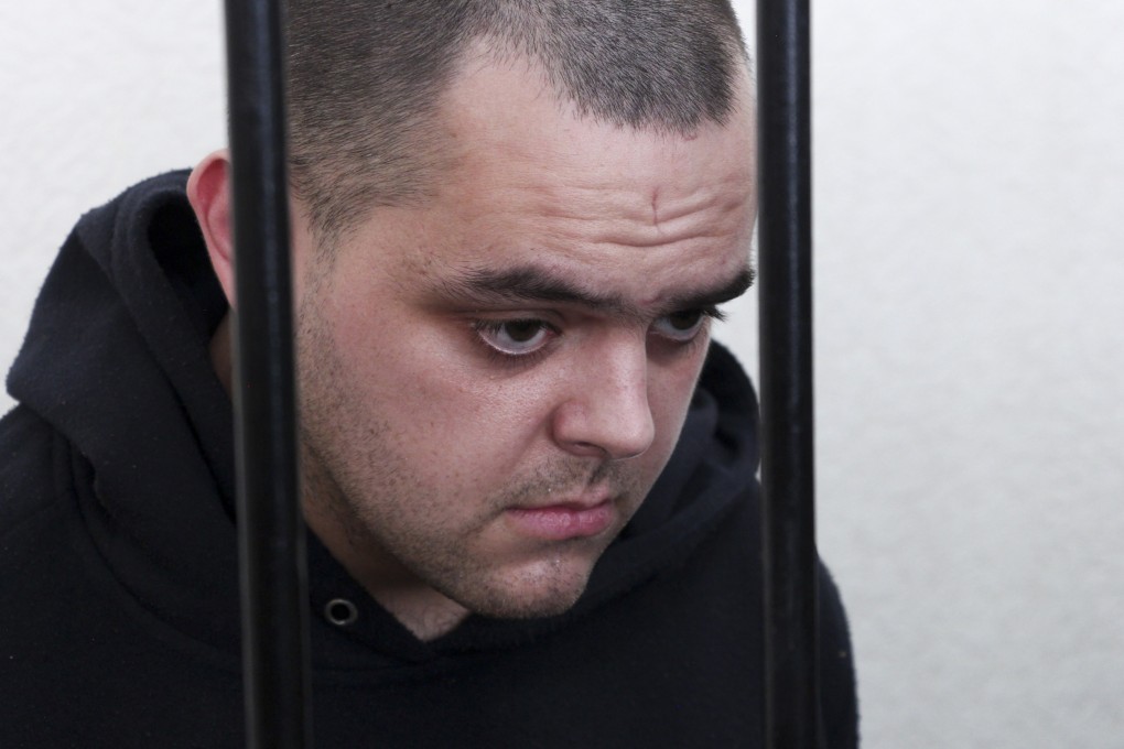 British citizen Aiden Aslin stands behind bars in a courtroom in Donetsk, on June 9, 2022. Photo: AP