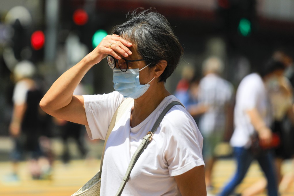 A woman wears a mask in Causeway Bay during an unseasonably hot day on September 15. Recent rule changes have eased the burden on people arriving in Hong Kong, but many pandemic-related restrictions such as the mask mandate remain. Photo: Xiaomei Chen