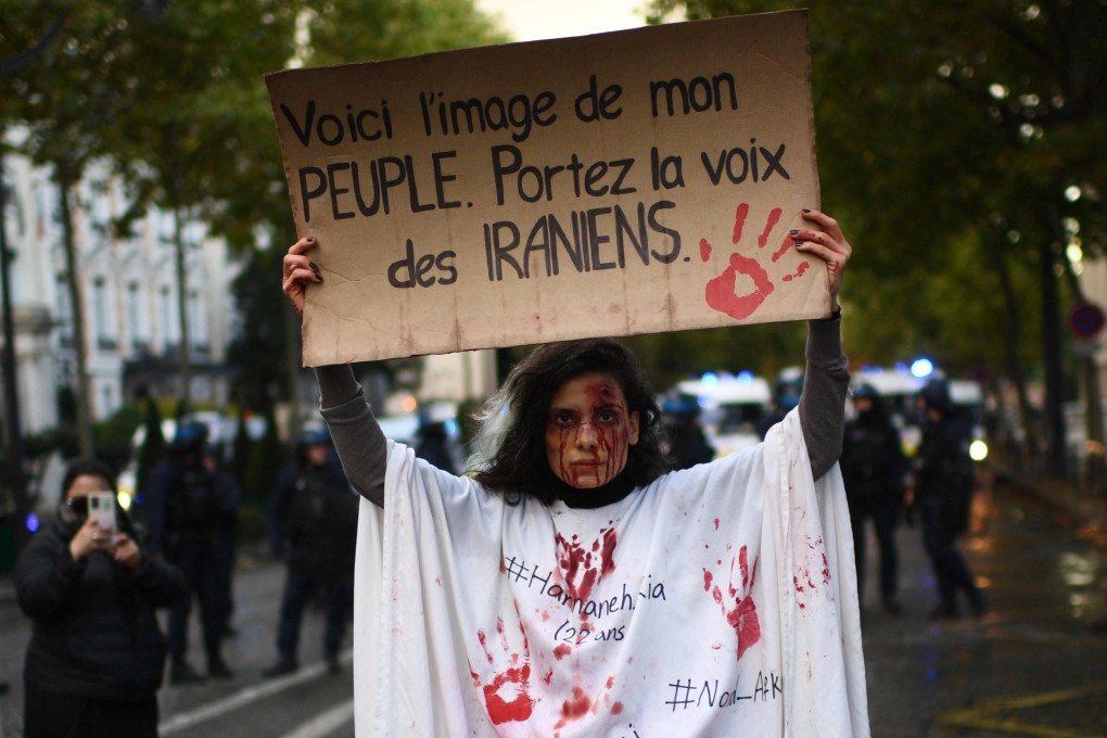 A protester holds a banner reading “This is the image of my people. Carry the voice of the Iranians” as she stands in front of riot police in Paris during a demonstration in support of Iranian protesters on Sunday. Photo: AFP