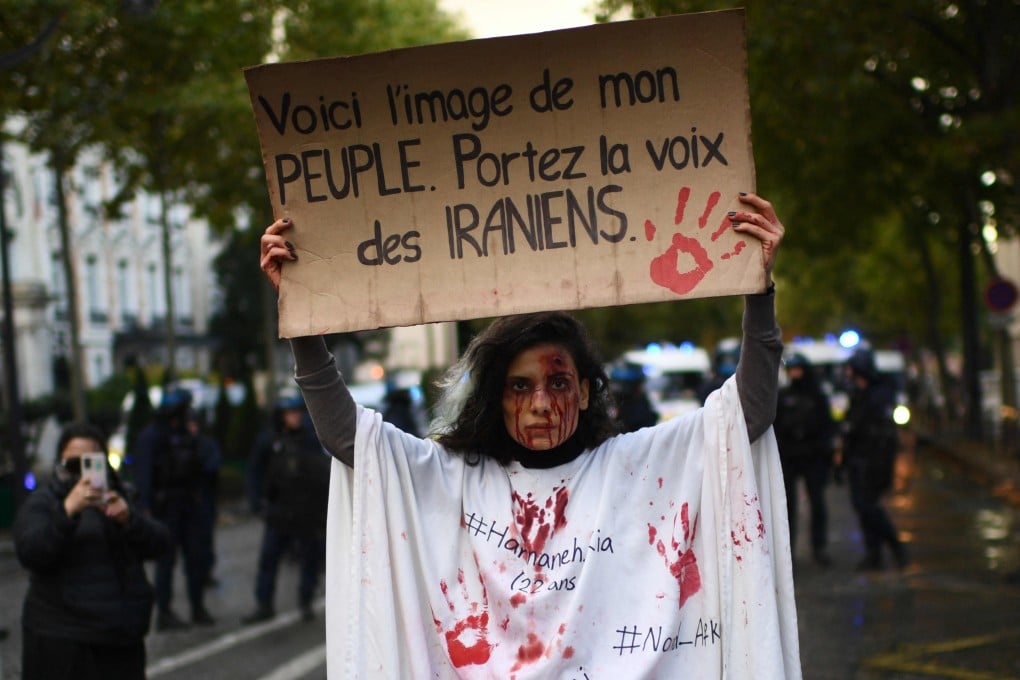 A protester holds a banner reading “This is the image of my people. Carry the voice of the Iranians” as she stands in front of riot police in Paris during a demonstration in support of Iranian protesters on Sunday. Photo: AFP