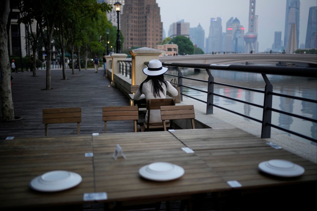 A woman sits at a riverside table at a restaurant in Shanghai on September 6, 2022. Photo: Reuters