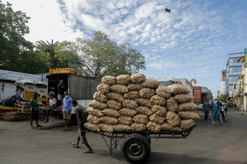 A hand-cart puller carries sacks of onions at a local market in Colombo, Sri Lanka. Photo: EPA-EFE