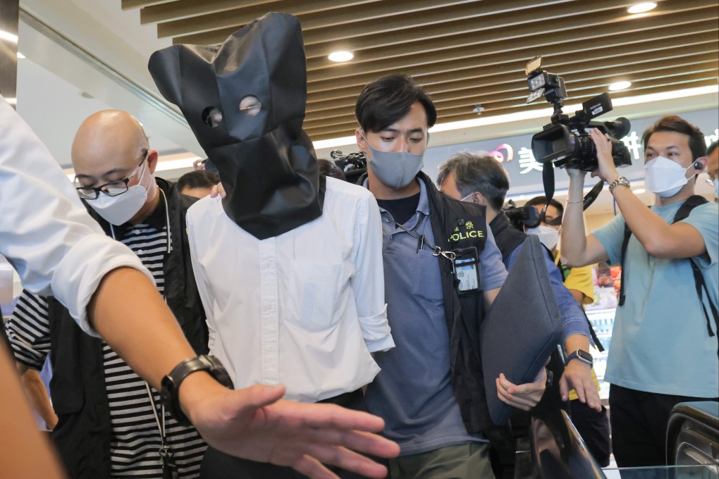 Officers escort one of the seven suspects from his clinic in Chai Wan. Photo: Jelly Tse