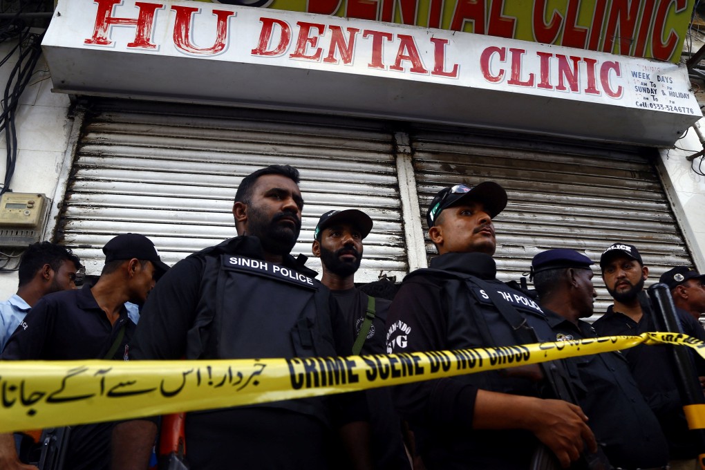 Police officers stand guard after an armed attacker posing as a dental patient killed a Chinese national and injured others at a clinic in Karachi on Wednesday. Photo: Reuters
