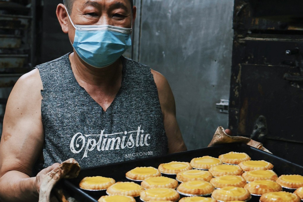 Long-time baker Hui Fu (known as Fu Gor) holds a tray of Hoover Cake Shop’s signature egg tarts. The Academics Group will reopen the bakery next year with staff including Hui, at a location to be decided. Photo: The Academics Group