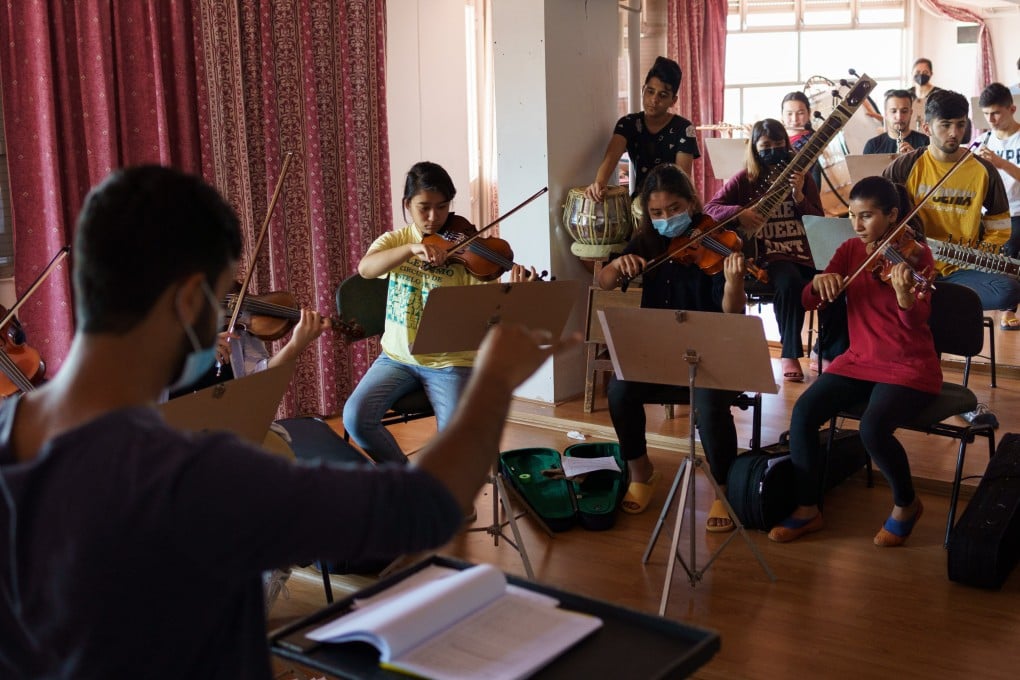 Mohammad Qambar Nawshad, of the Afghanistan National Institute of Music, conducts an orchestra in a former military hospital in Lisbon, Portugal, in May. Photo: Thomas Cristofoletti / Ruom