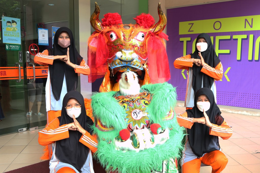 The Indolion-Muhammadiyah Troupe pose with their Chinese lion decorated with Arabic calligraphy. Photo: Johannes Nugroho