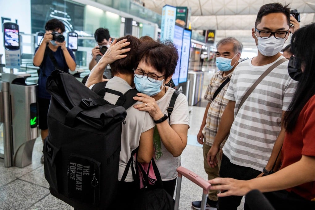 Two women hugging at the departure gates of Hong Kong’s International Airport. Elderly parents are forced to choose family over friends if they wish to follow their emigrant children. Photo: AFP