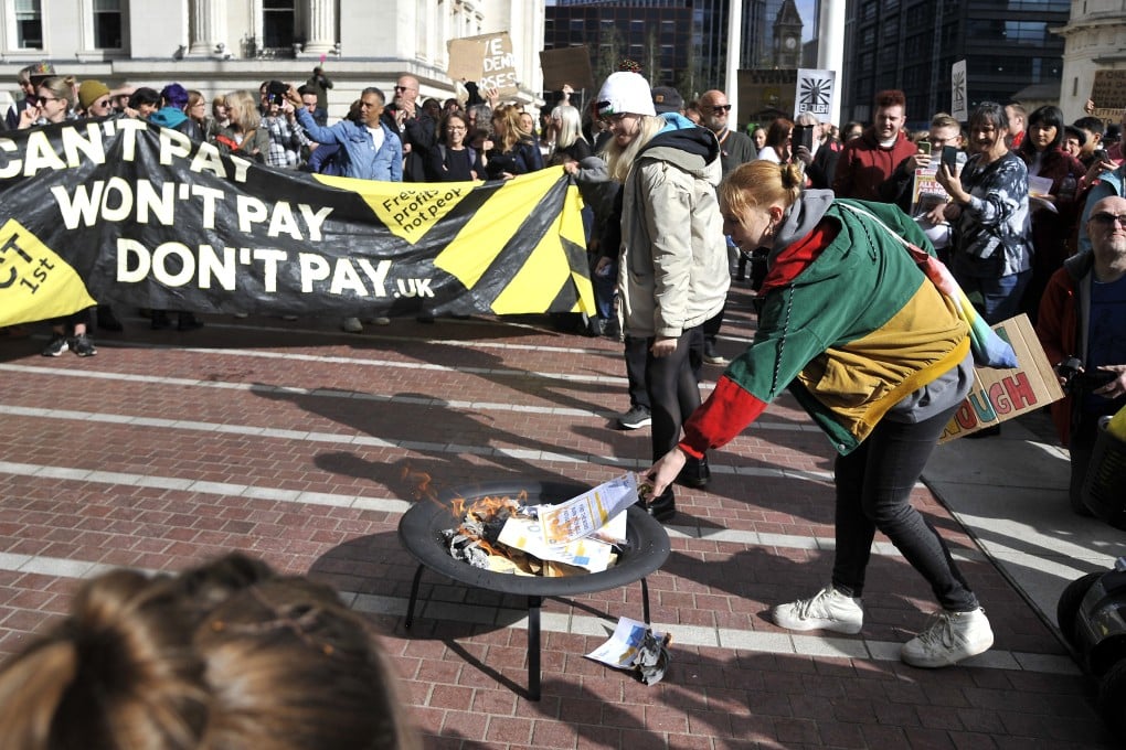 Protesters burn symbolic energy bills outside the ICC in Birmingham, England, on Saturday. Photo: AP