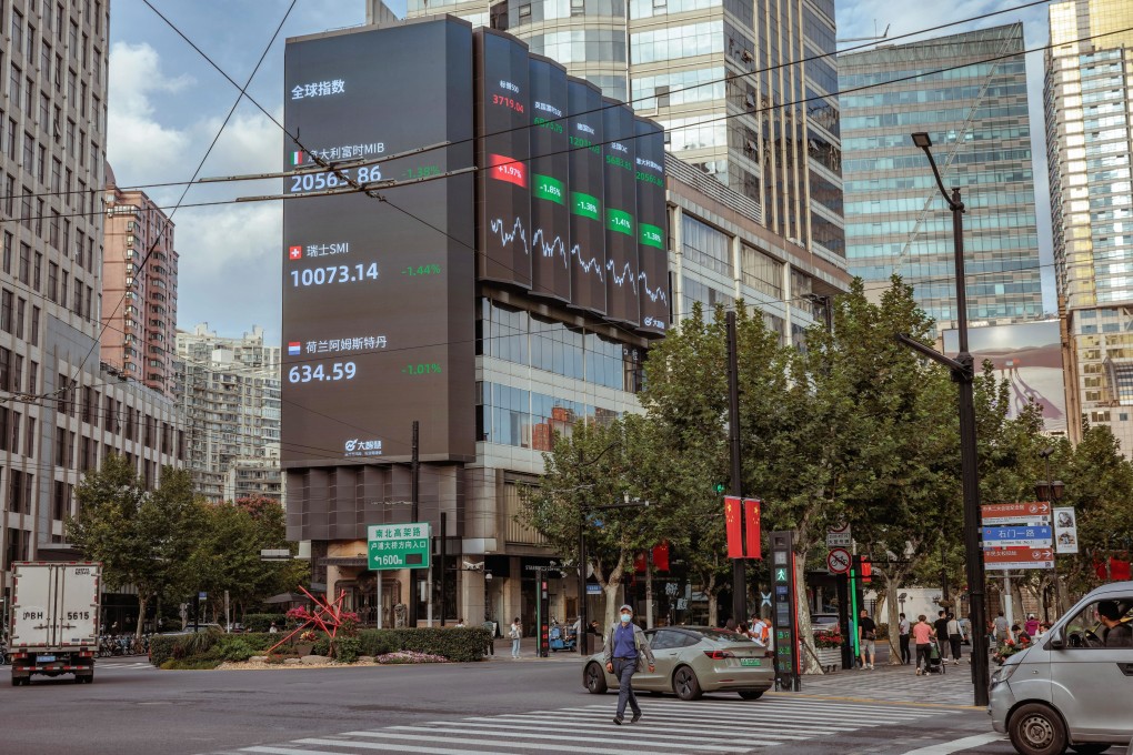 A man walks past the large screen showing latest stock and currency exchange data in Shanghai on September 29. Photo: EPA-EFE