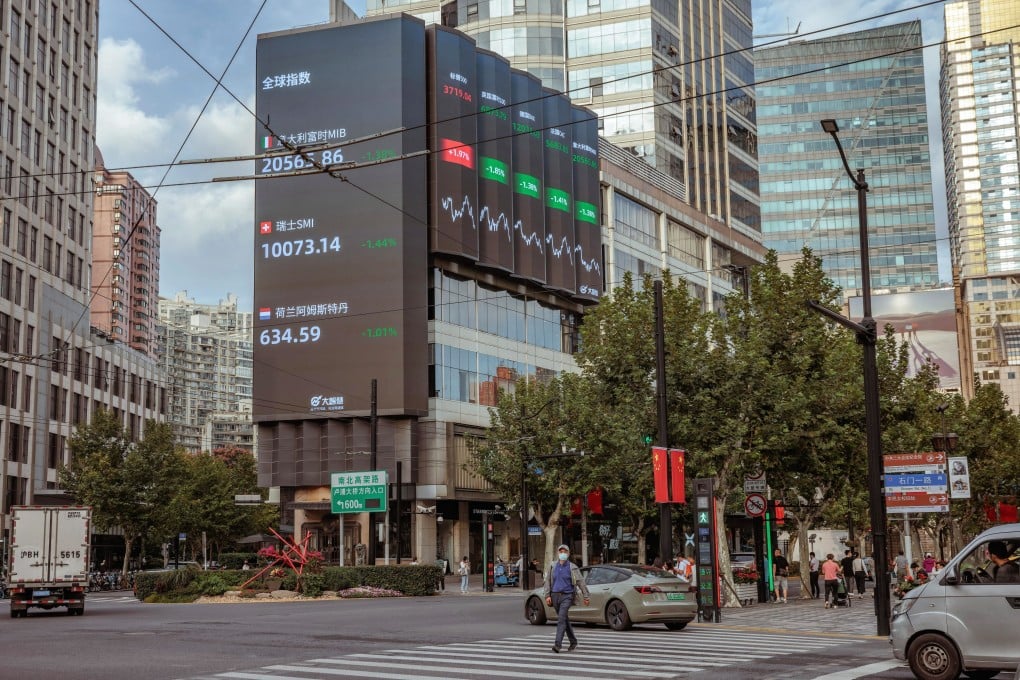A man walks past the large screen showing latest stock and currency exchange data in Shanghai on September 29. Photo: EPA-EFE