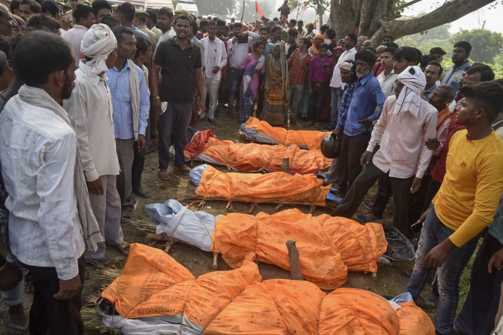 Villagers gather around the bodies of victims of a road accident in India on Sunday. A tractor pulling a wagon loaded with people overturned and fell into a pond, killing 26, most of them women and children. Photo: AP
