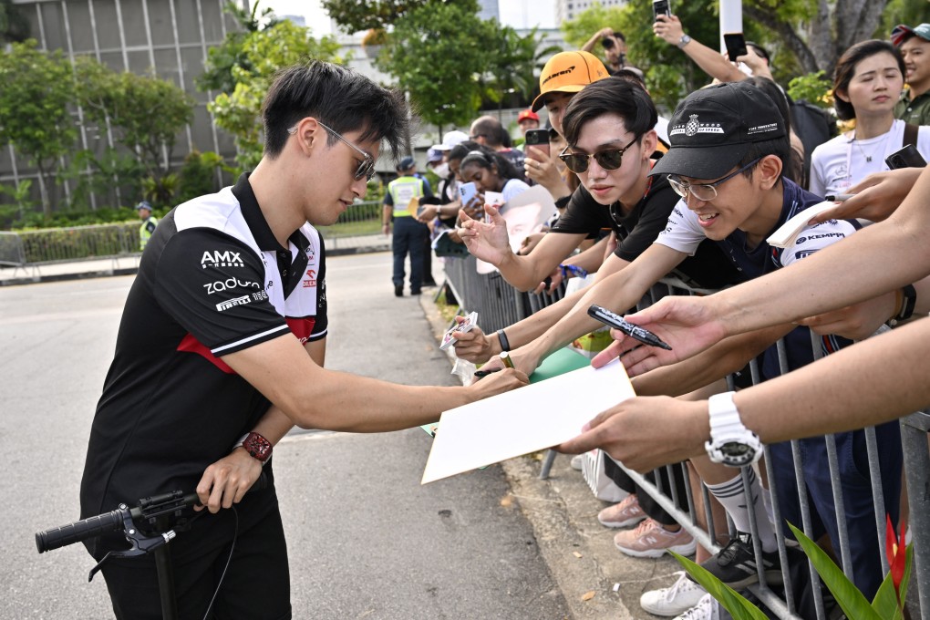 Alfa Romeo’s Guanyu Zhou signs autographs for fans ahead of practice at Marina Bay Street Circuit in Singapore. Photo: Reuters