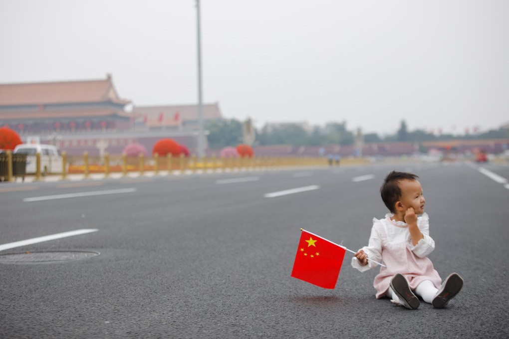 A child holds the Chinese flag in Beijing’s Tiananmen Square at the start of the National Day holiday. Photo: EPA-EFE