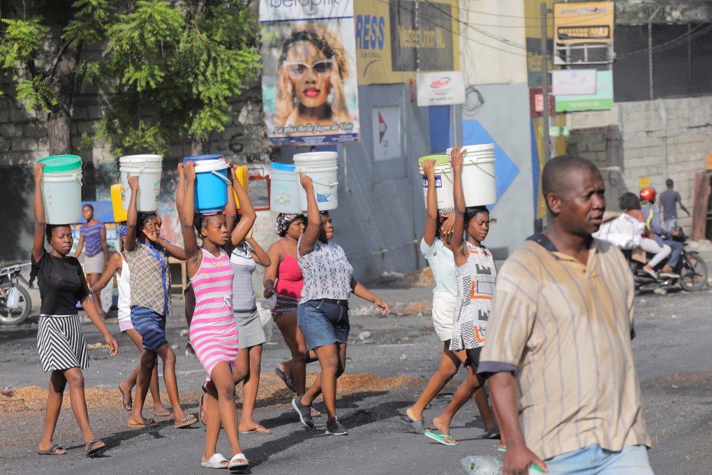 Women carry buckets filled with water amid shortages of water, cooking gas and other items in Port-au-Prince, Haiti. Photo: Reuters