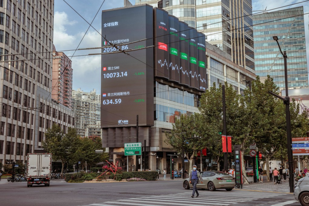 A man walks past the large screen showing stock and currency exchange data in Shanghai on September 29. The yuan hit a record low against the US dollar on September 28, the weakest since the global crisis in 2008. The central bank is taking steps to rein in yuan weakness. Photo: EPA-EFE
