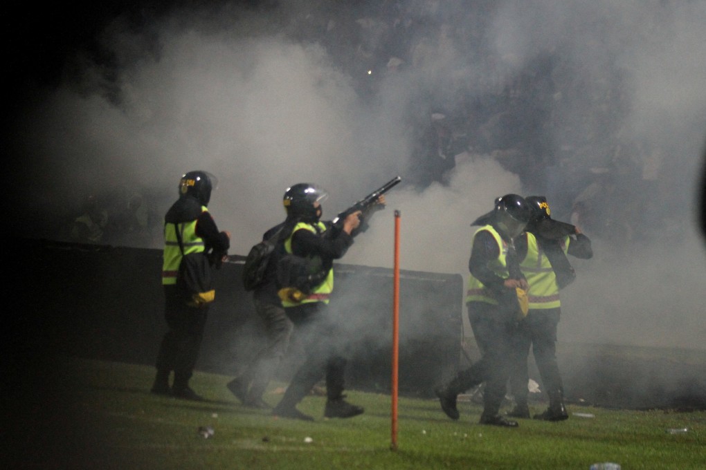 A riot police officer fires tear gas during a after a football match between Arema vs Persebaya at Kanjuruhan Stadium in Malang, East Java province, Indonesia on Sunday. Photo: Antara Foto/Ari Bowo Sucipto/via Reuters