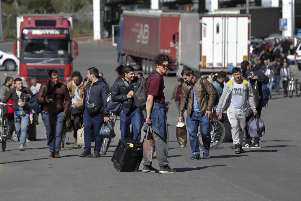 A group of Russians walk into Georgia after crossing the Verkhny Lars border on September 27. Long lines of vehicles formed at the border crossing after Moscow announced a partial military mobilisation. Photo: AP