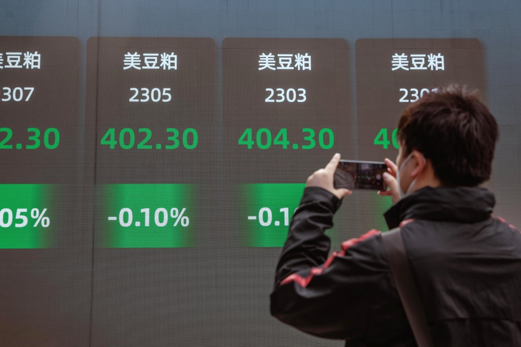 A man takes a photo of the large screen showing latest stock and currency exchange data in Shanghai on September 29. Photo: EPA-EFE
