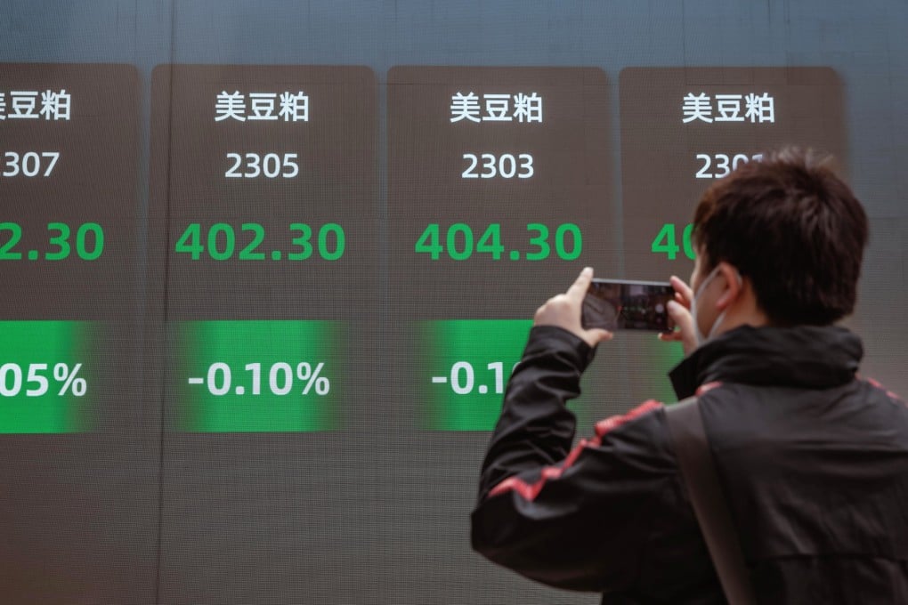A man takes a photo of the large screen showing latest stock and currency exchange data in Shanghai on September 29. Photo: EPA-EFE