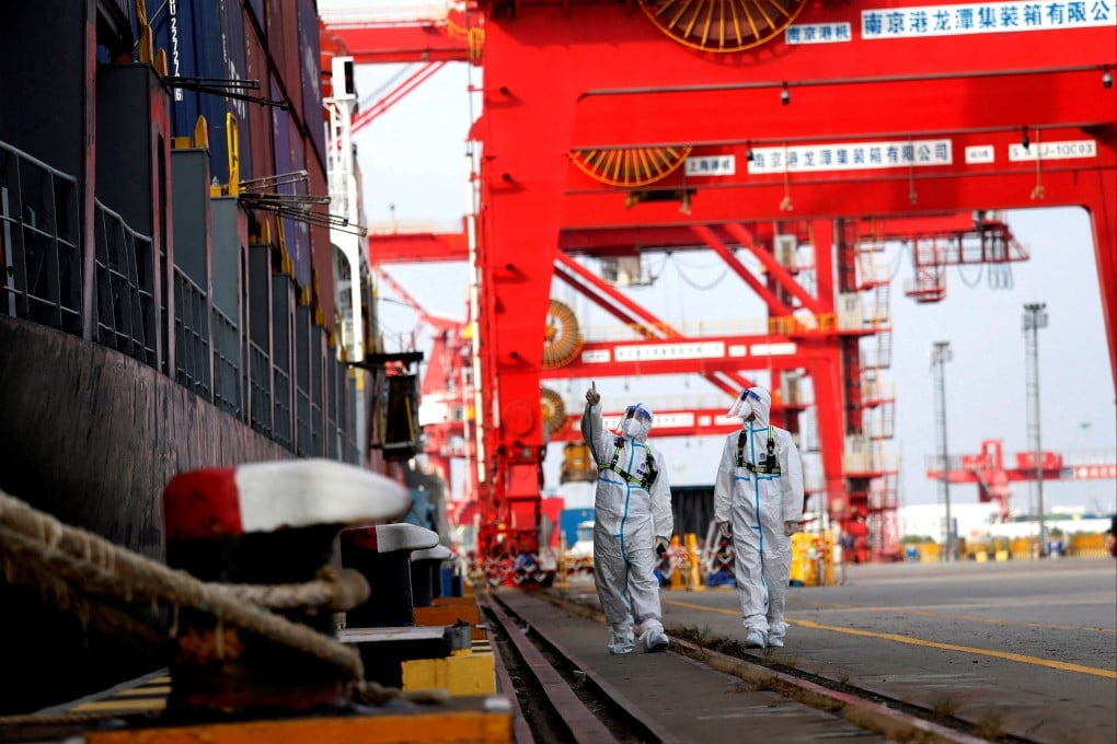Border police patrol next to a container ship at a port in Nanjing, China, on July 10. Photo: China Daily/Reuters