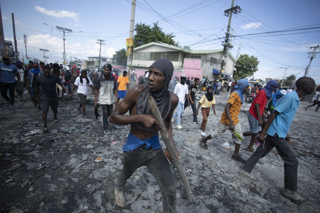 A protester carries a piece of wood simulating a weapon during a protest demanding the resignation of Prime Minister Ariel Henry, in the Petion-Ville area of Port-au-Prince, Haiti. Photo: AP