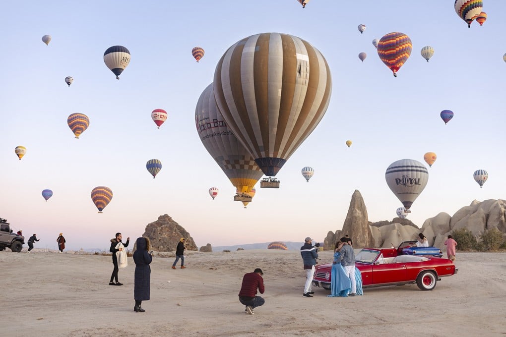 An image from photographer Natacha de Mahieu’s new series “Theatre of Authenticity” of Cappadocia, in Türkiye, where thousands of travellers jostle for space each morning to take selfies and pose on vintage cars. Photo: Natacha de Mahieu