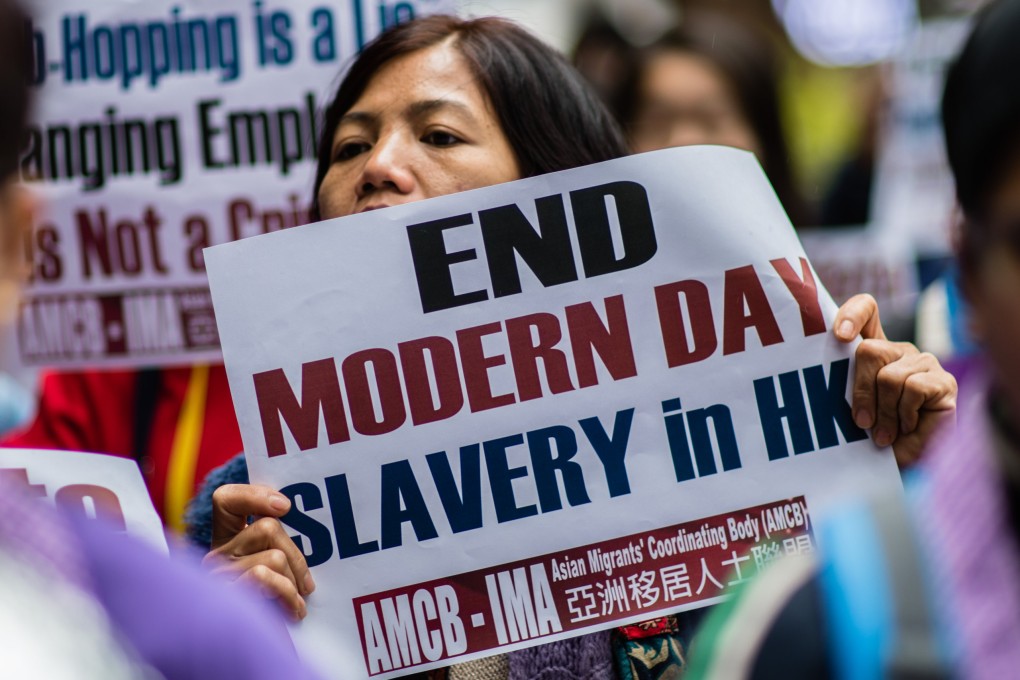 An activist from the Asian Migrants Coordinating Body holds a placard during a protest urging the Immigration Department to review its accommodation and visa polices for foreign domestic helpers in Hong Kong in 2018. Photo: AFP