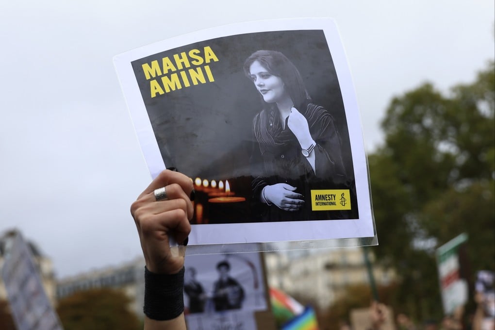A protester shows a portrait of Mahsa Amini during a demonstration to support Iranian protesters standing up to their leadership over the death of a young woman in police custody. Photo: AP/File
