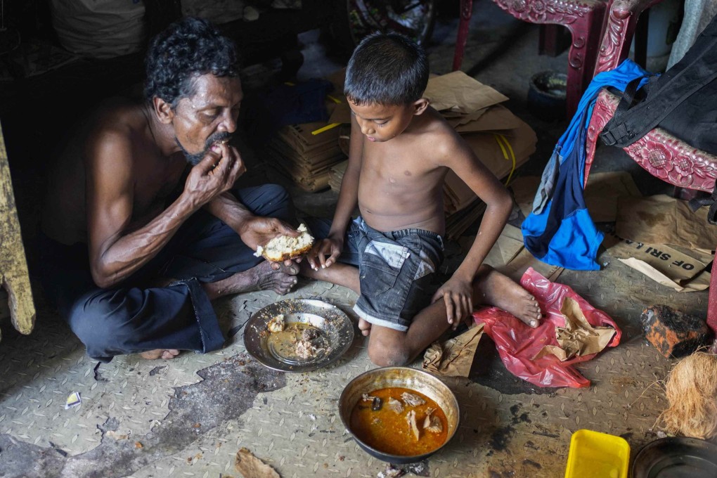 A father and son share a meal at their shanty home in Colombo, Sri Lanka, on October 5. The country is currently facing its worst economic crisis in decades. Photo: AP