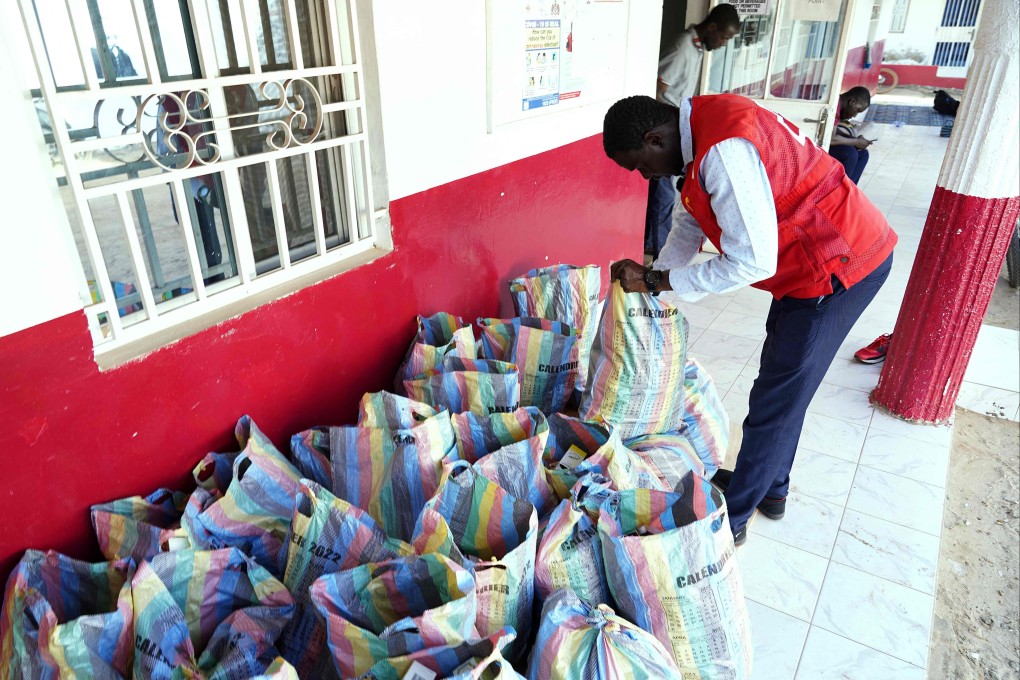 A member of the Gambian Red Cross looks through sacks of collected cough syrups in Banjul, Gambia on Thursday. Photo: AFP