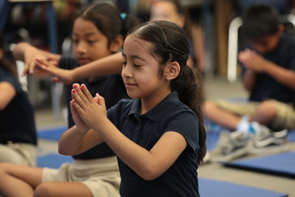 Students practise a breathing exercise at Accelerated Charter Elementary School in Los Angeles. Many schools in the US like this one are adopting yoga programmes to help children create a sense of internal peace and bolster their resilience. Photo: TNS