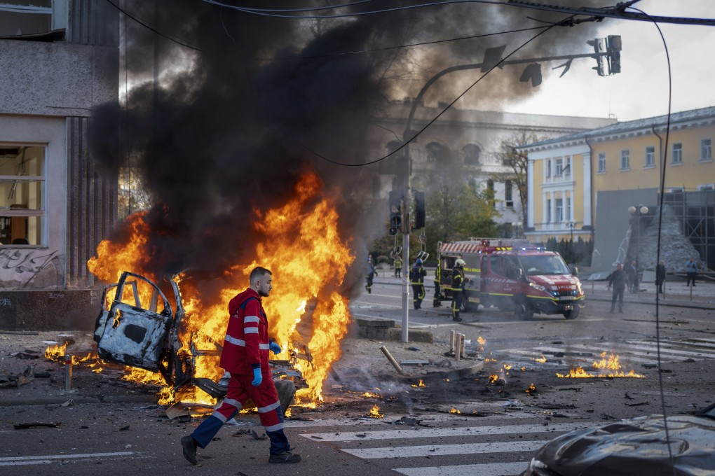 A medical worker hurries past a burning car after a Russian attack in Kyiv, Ukraine on Monday. Photo: AP
