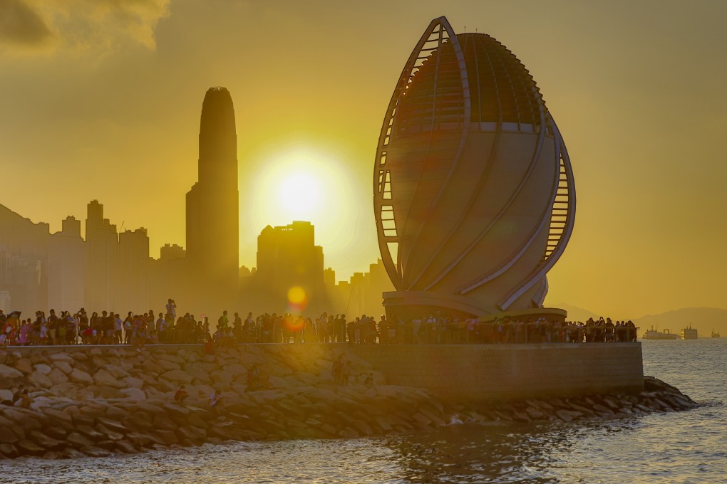 People take photographs of the sunset at East Coast Park Precinct, along the waterfront in Fortress Hill. Victoria Harbour, one of the world’s renowned deepwater harbours, has been preserved for the enjoyment of Hongkongers since 1997. Photo: Dickson Lee