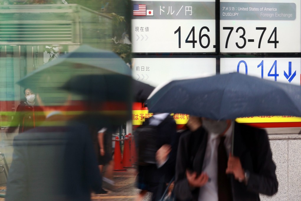Pedestrians walk past a screen displaying the Japanese yen exchange rate against the US dollar in Tokyo on October 13, 2022. The yen fell against the US dollar to reach the upper 146 range. Photo: EPA-EFE/Jiji Press
