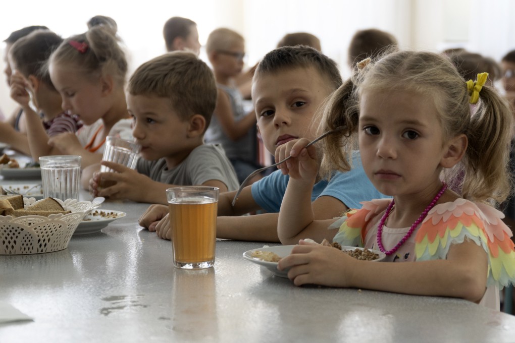 Children from an orphanage in the Donetsk region eat a meal at a camp in Zolotaya Kosa in southwestern Russia in July. Photo: AP,