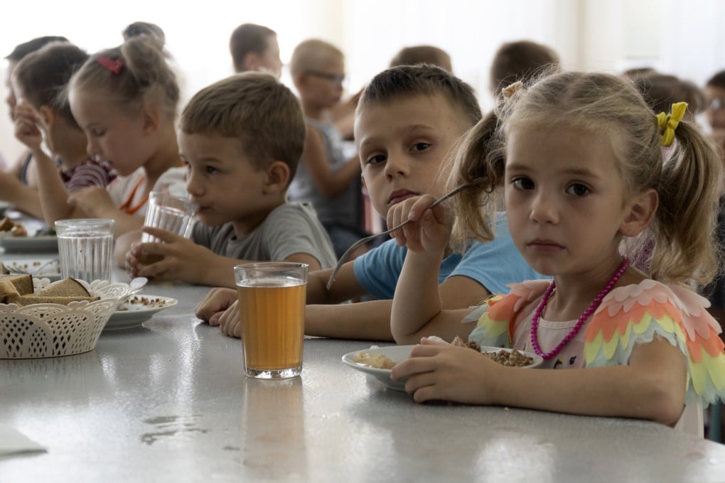 Children from an orphanage in the Donetsk region eat a meal at a camp in Zolotaya Kosa in southwestern Russia in July. Photo: AP,