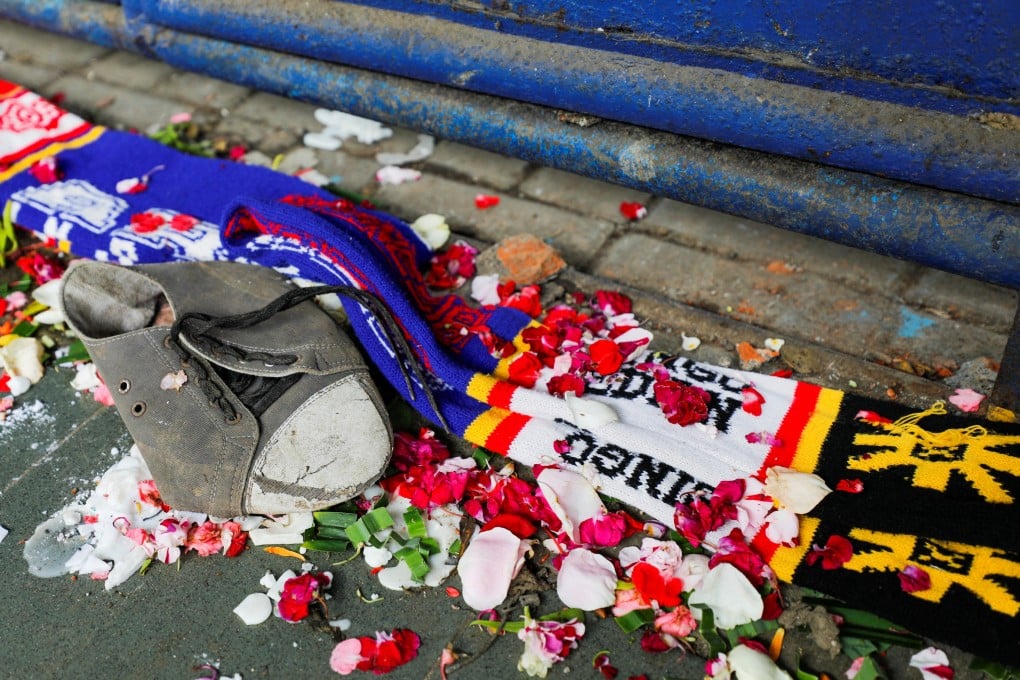 A shoe and soccer scarves are seen among petals near a gate of Kanjuruhan Stadium, after a riot and stampede following soccer match in Indonesia killed at least 130 people. Photo: Reuters/File