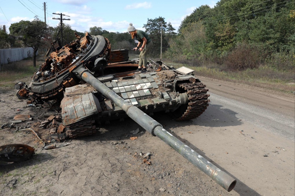 A girl inspects a destroyed Russian tank near the village of Oskol, Kharkiv region, on Sunday. Photo: AP
