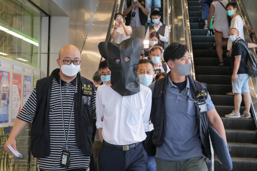 Police officers escort a suspect from a clinic in Chai Wan last month. The use of fake vaccine exemption certificates, allegedly issued by seven doctors, has been condemned by medical professionals and the wider community. Photo: Jelly Tse