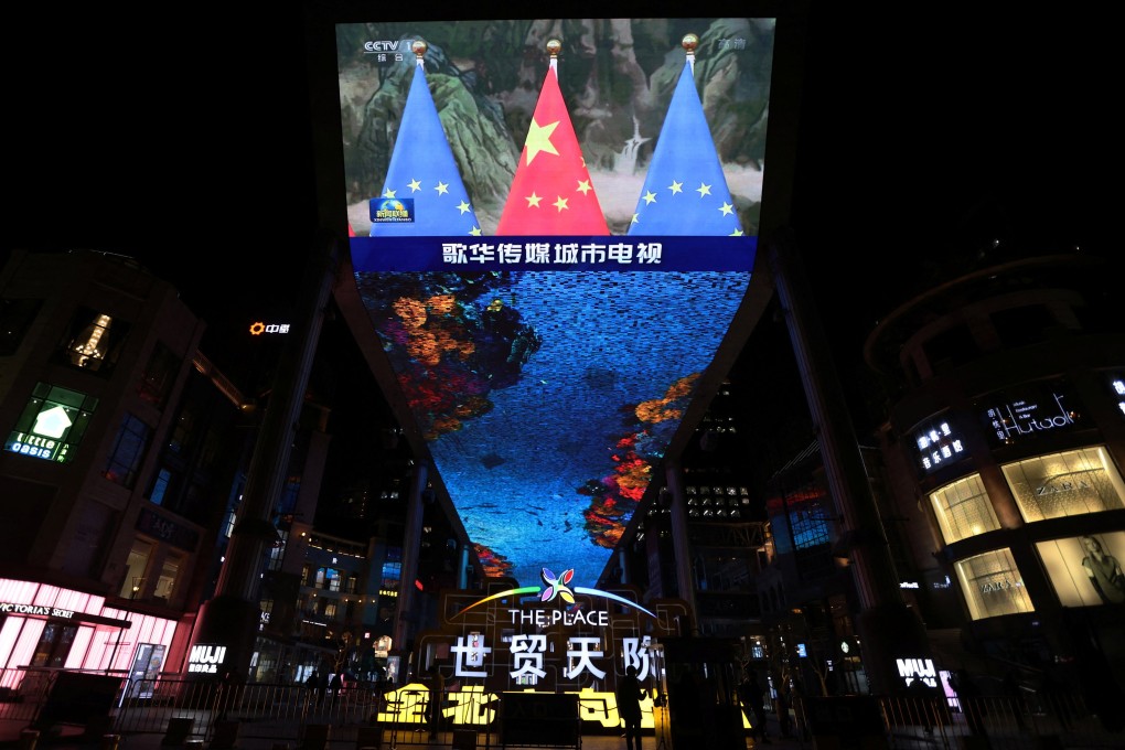 A giant screen shows news footage of Chinese national flags and European Union flags during an EU-China virtual summit, in Beijing in April 2022. Photo: Reuters