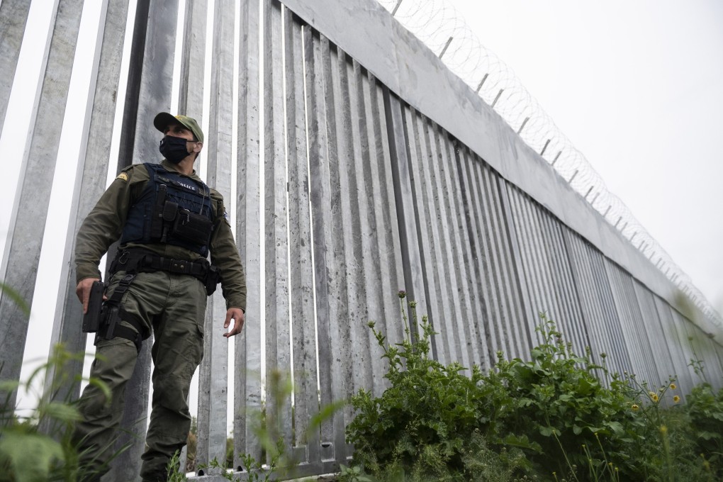 A policeman patrols alongside a steel wall at Evros river, near the Greek -Turkish border in Greece. Greek government ministries say border guards have intercepted 92 naked migrants who were forced to cross the river on Friday. Photo: AP