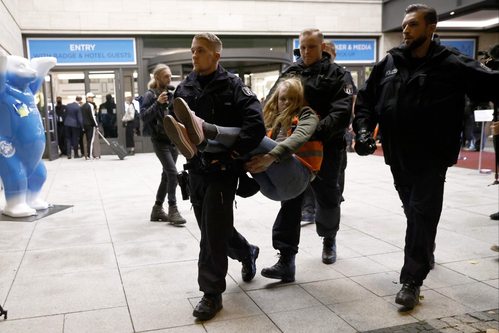 Police officers remove a climate activist on Sunday in front of the Berlin hotel where the World Health Summit is taking place. Photo: dpa