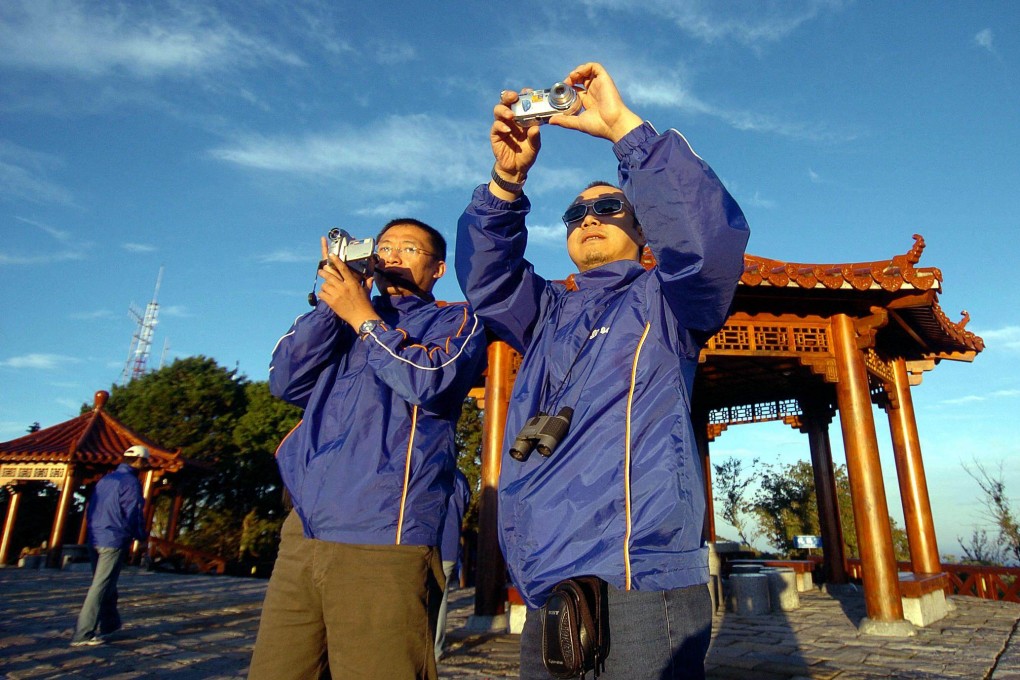 Mainland tourists take pictures of the sunrise at the Alishan tourist spot in Taiwan in June 2005. Picture: AFP