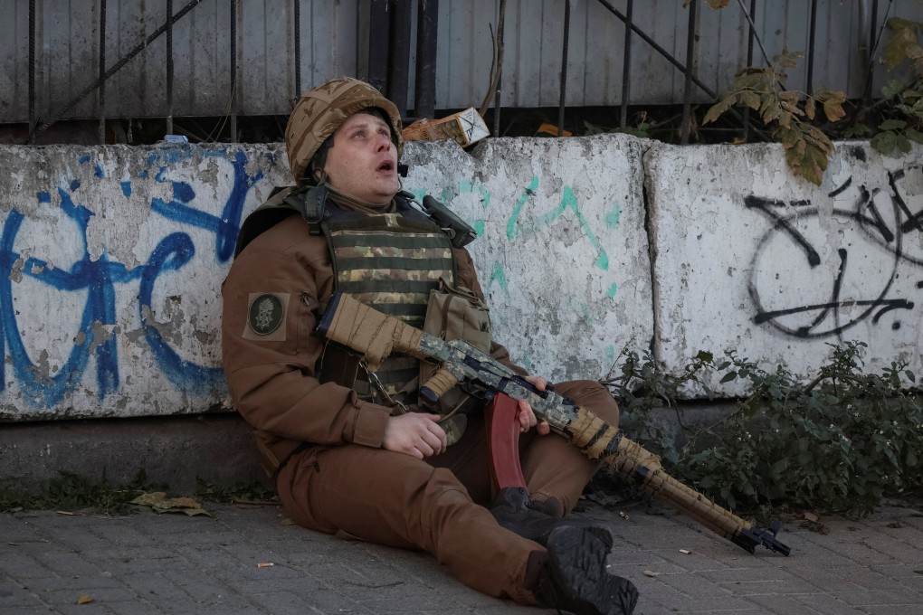 A Ukrainian serviceman takes cover as an air-raid siren sounds during a Russian drone strike in Kyiv on Monday. Photo: Reuters