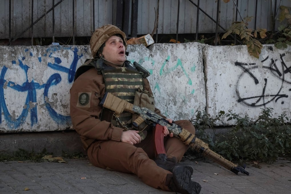 A Ukrainian serviceman takes cover as an air-raid siren sounds during a Russian drone strike in Kyiv on Monday. Photo: Reuters