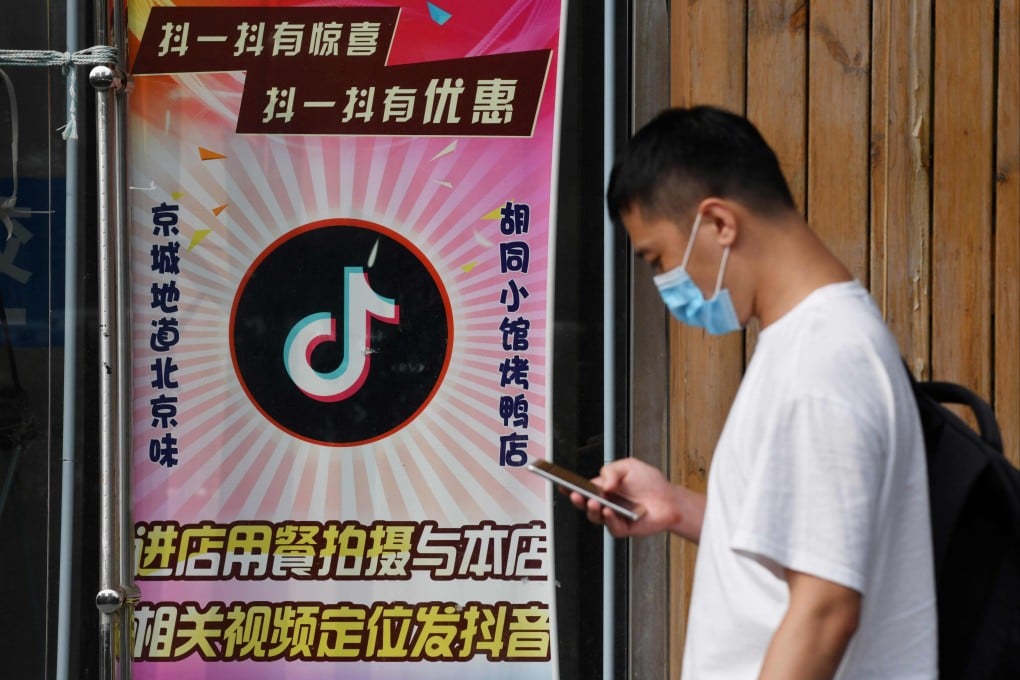 A man walks past a restaurant with a Douyin logo displayed on the window in Beijing on September 14, 2020. Photo: AFP