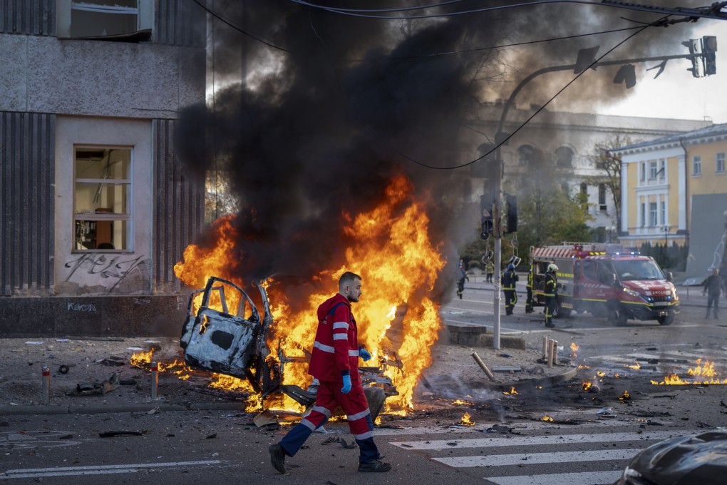 A medical worker walks past a burning car after a Russian attack on Kyiv, Ukraine, on October 10. Photo: AP
