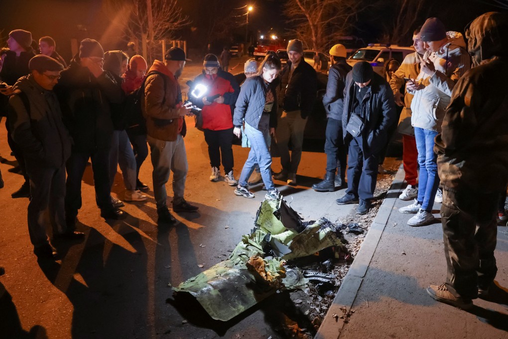 People gather around remains of a military plane that crashed into a residential building in the city of Irkutsk, Russia. Photo: Reuters